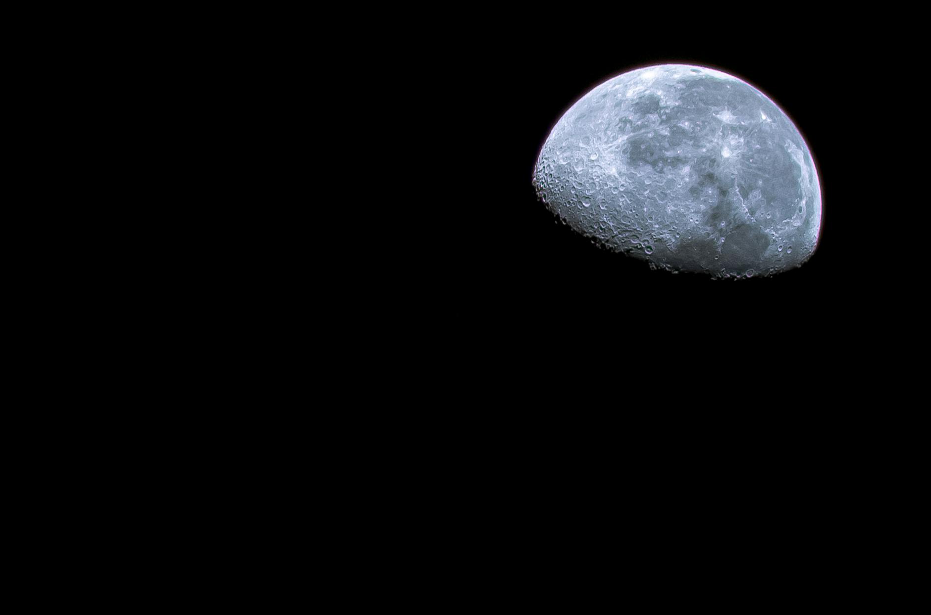 Półksiężyc z wyraźnymi kraterami na nocnym niebie nad Florydą