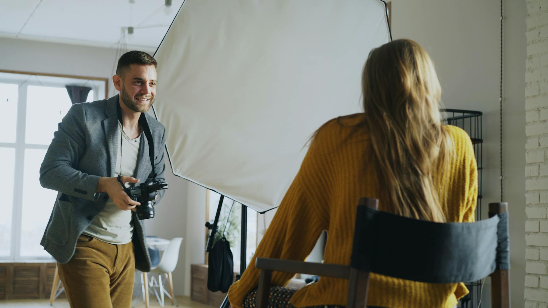 Fotograf robi portret modelce w studiu z profesjonalnym oświetleniem