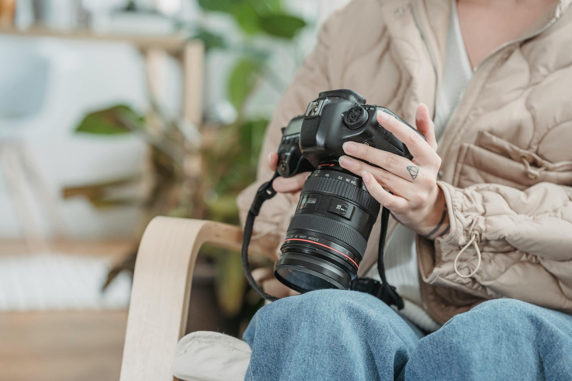 Fotograf w casualowym stroju siedzi w pomieszczeniu z lustrzanką
